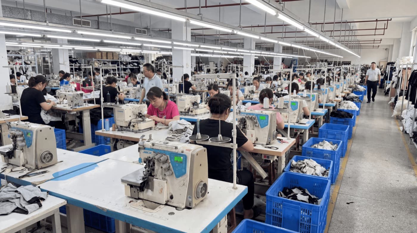 Chão de fábrica de confecção com máquinas de costura